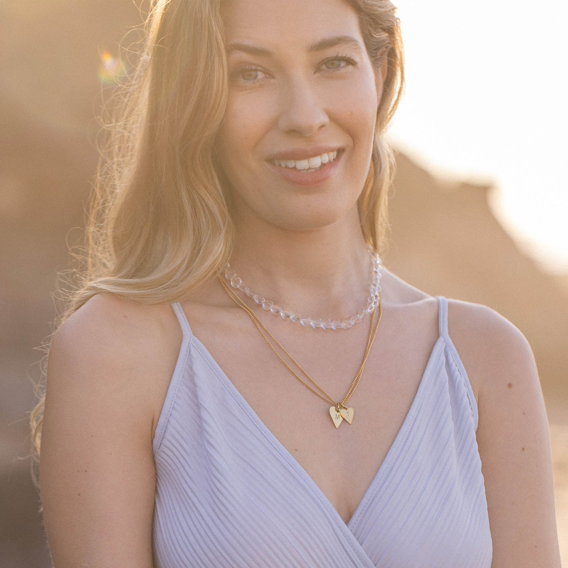 Zwei elegante Ketten von PURELEI, eine goldene mit Herzanhänger und eine aus klaren Perlen.