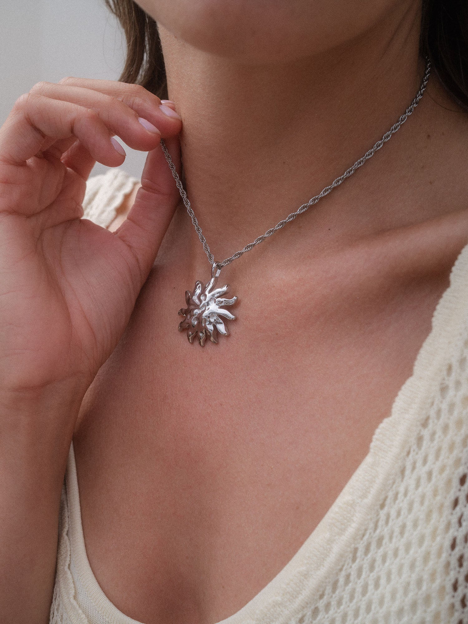 Iconic Sun Charm Halsschmuck aus silberfarbenem Edelstahl, sonneninspiriertes Design, getragen für pure Eleganz von PURELEI.