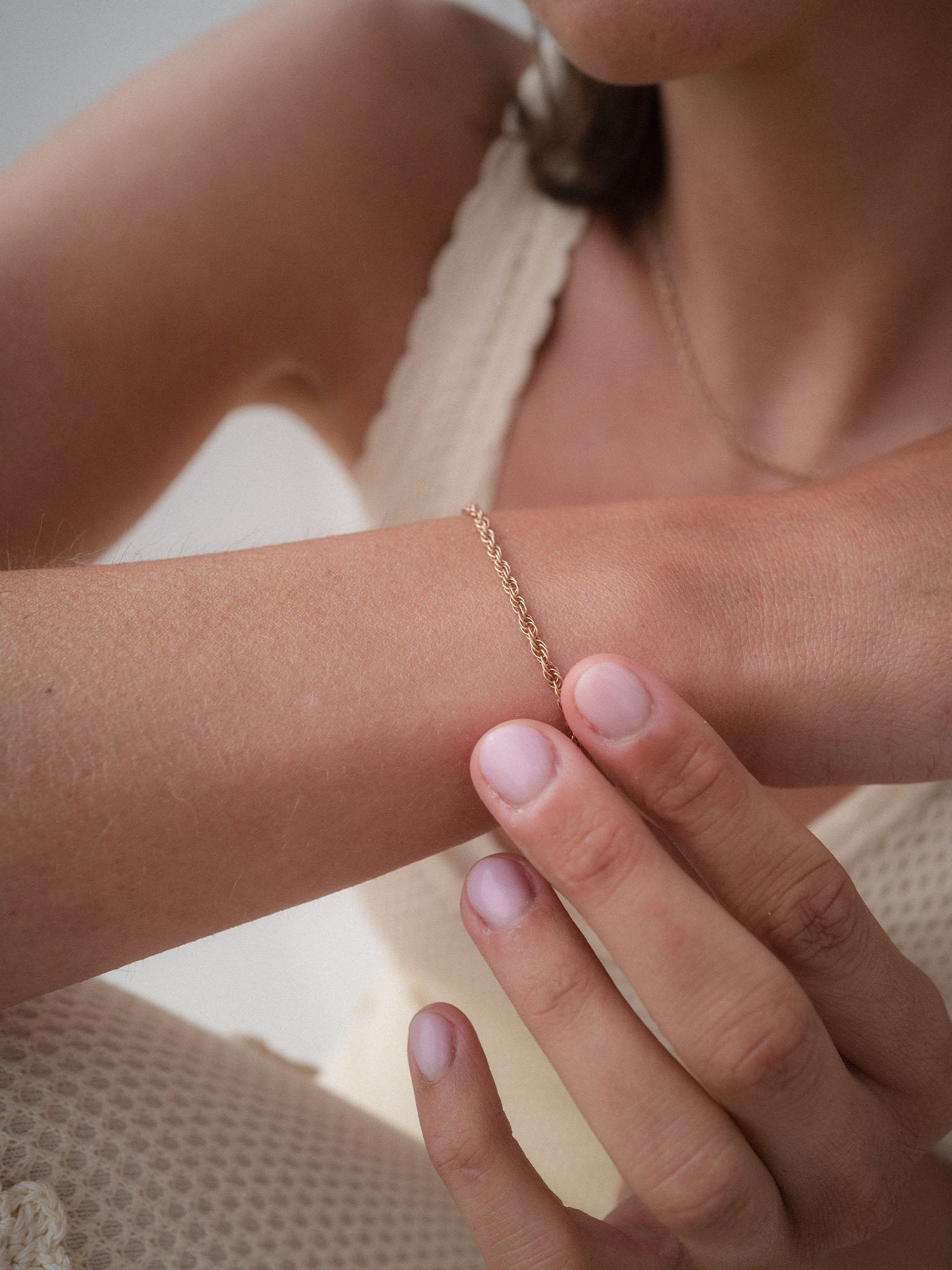 Silbernes Armband mit feiner Kettengliederung, getragen am Handgelenk, PURELEI Stil.