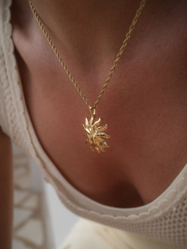 PURELEI Iconic Sun Charm aus 14K vergoldetem Edelstahl mit strukturiertem Sonnenanhänger, elegant und feminin getragen.