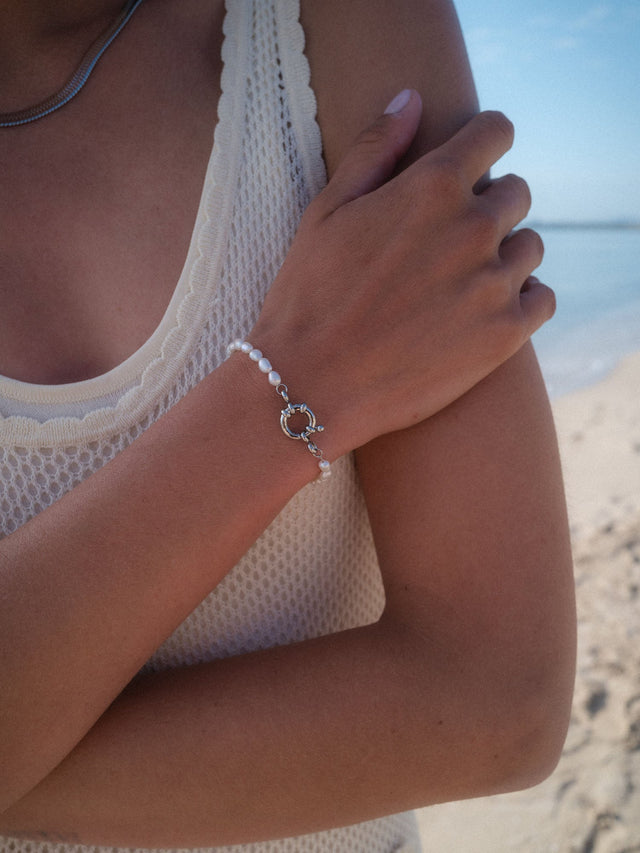 Charm Armband mit Perlen aus Silber mit Süßwasserperlen, am Handgelenk am Strand, PURELEI Eleganz.